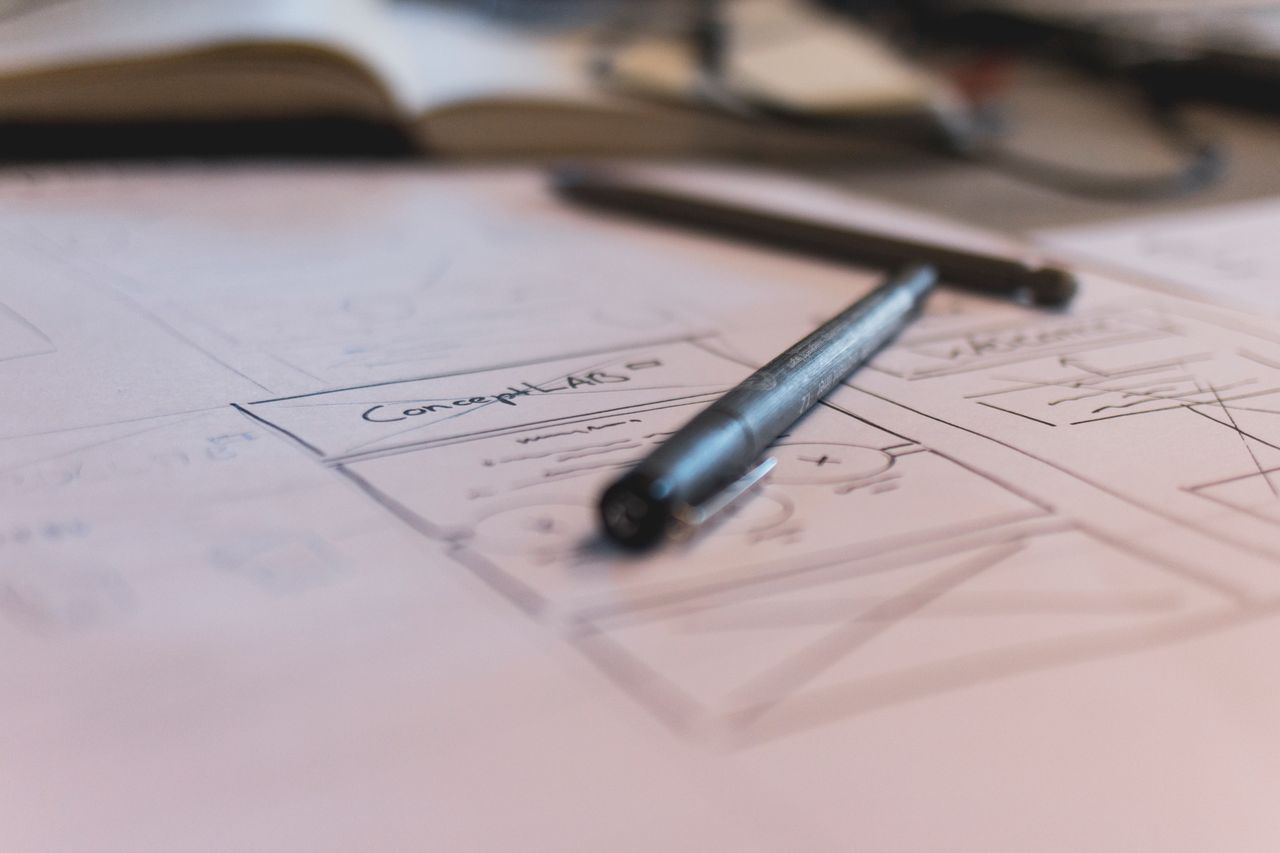 services-01 A sketch with notes and a pen on paper. Ideal for planning or design concepts.