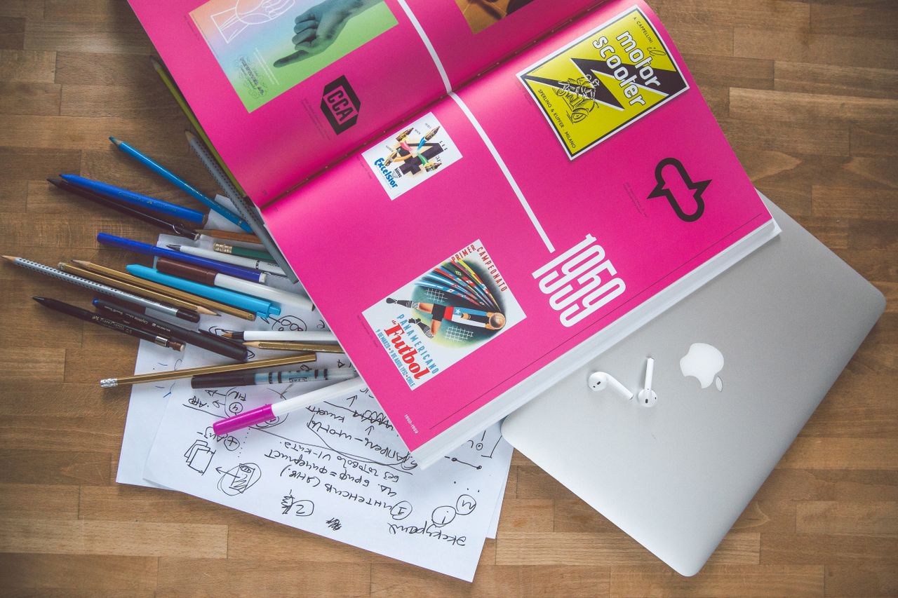 services-02 A bright desk setup featuring a design book, laptop, and creative tools, ideal for inspiration.